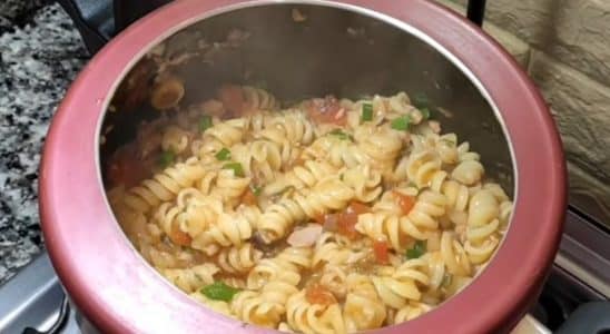 Macarrão com atum sendo preparado em uma panela de pressão vermelha.