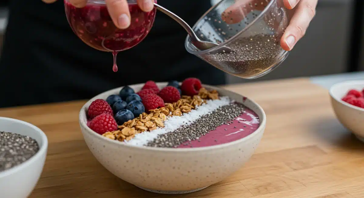 Close-up de um smoothie bowl colorido com frutas vermelhas, granola e chia, sendo preparado rapidamente em uma cozinha moderna.