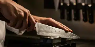 Chef afilando un cuchillo con una piedra de afilar tradicional