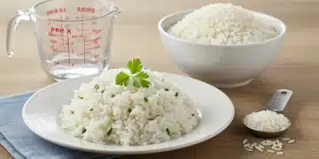 Arroz blanco perfectamente cocido y suelto en un plato con hierbas frescas.