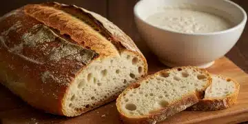 Pan artesano español de corteza crujiente y miga aireada en tabla de madera