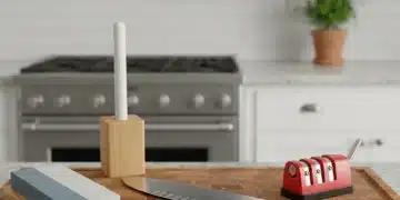 Cuchillo de cocina recién afilado sobre tabla de cortar con herramientas de afilado.