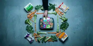 Aerial view of hands placing a bright pre-packaged meal next to discarded vegetable scraps and fast food wrappers on a concrete counter, symbolizing the pitfalls of convenience over nutrition in quick meals.